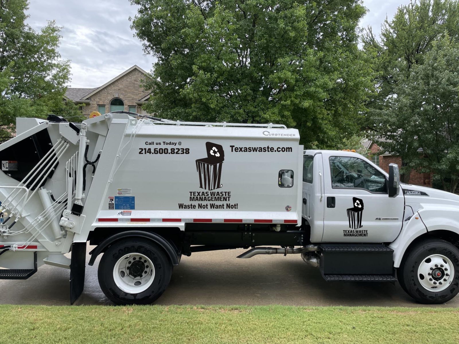 A white Texas Waste Management rear-loader collection truck parked on a residential street in North Texas.